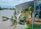 Tanah longsor menyebabkan sebuah rumah darurat runtuh ke sungai.
