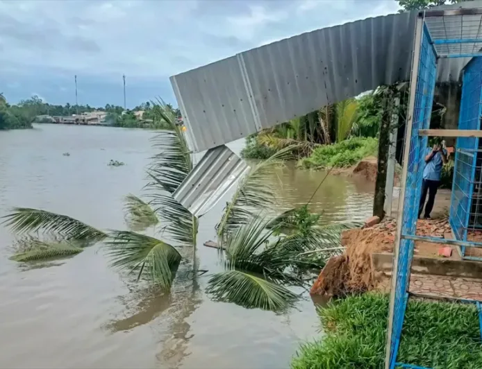 Tanah longsor menyebabkan sebuah rumah darurat runtuh ke sungai.